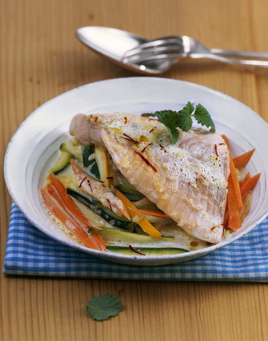 Salmon trout fillet with vegetables in saffron Prosecco sauce