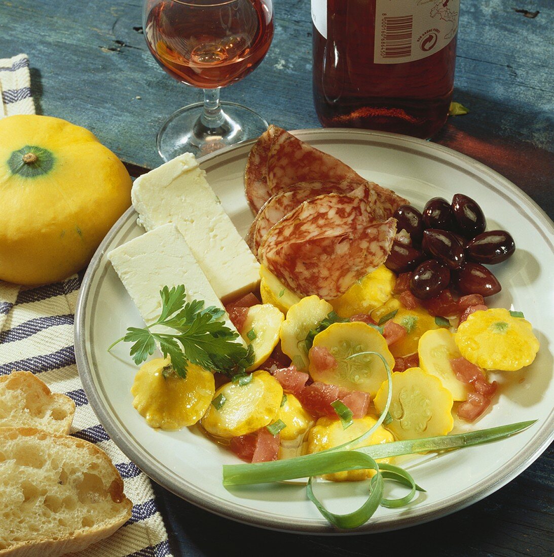 Plate of appetisers: patty pan squash, sheep's cheese, salami