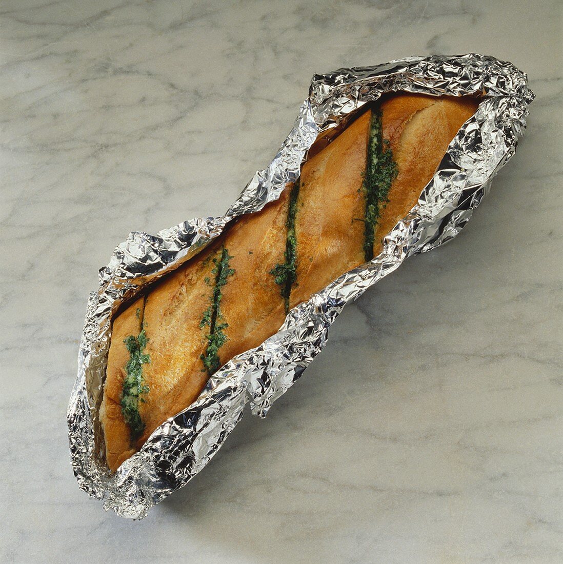 Grilled herb baguette in aluminium foil