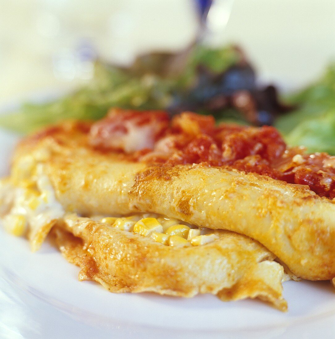 Pancake roll with sweetcorn filling and tomato sauce