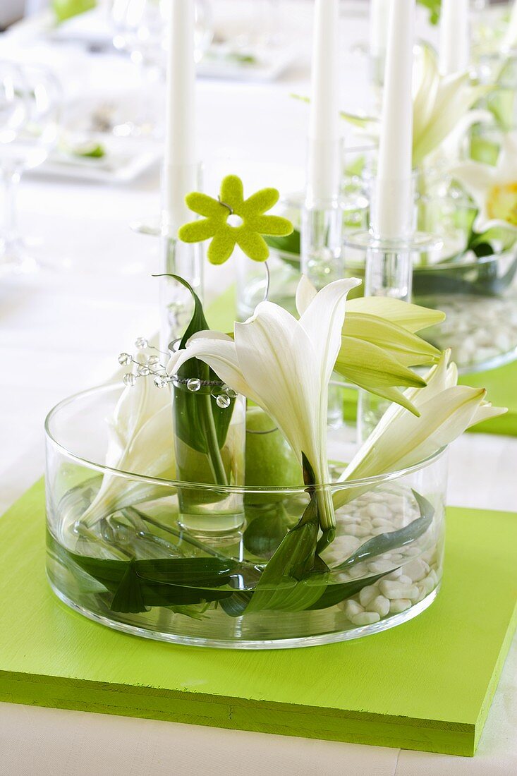 Flowers, leaves and pebbles in glass bowl