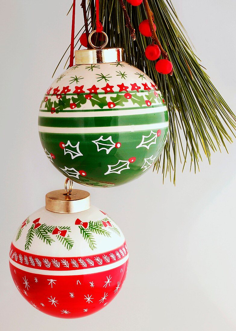 Two Christmas baubles on a pine branch