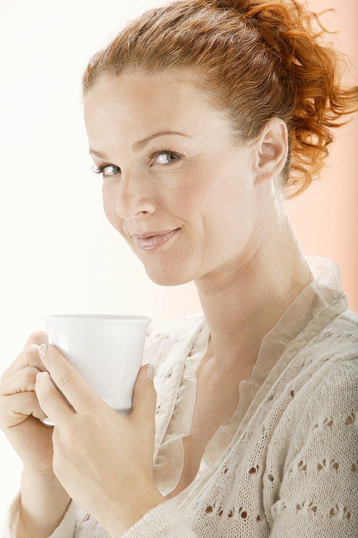 Red-headed woman holding a teacup
