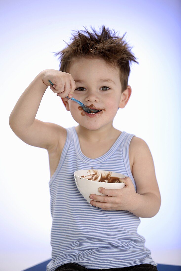 Kleiner Junge isst Schokopudding