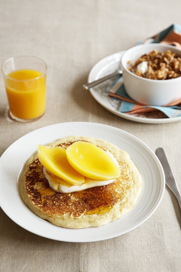 Pancakes with mango, muesli, orange juice