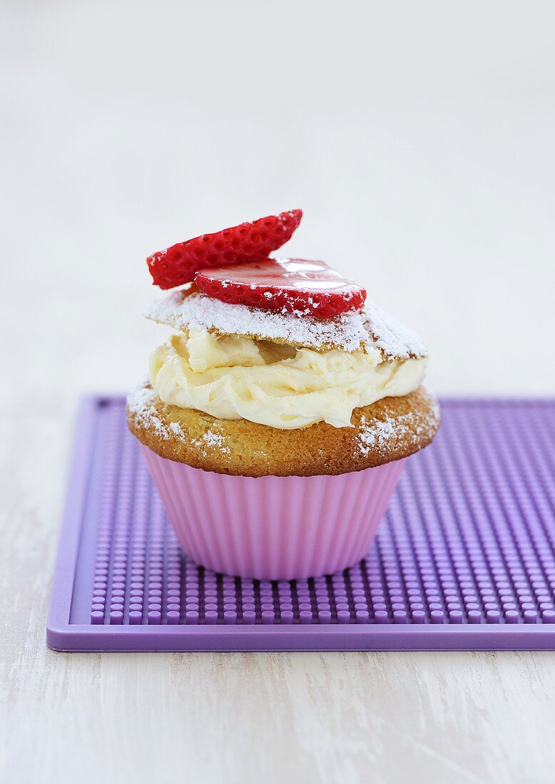 Cupcake with vanilla cream and strawberries