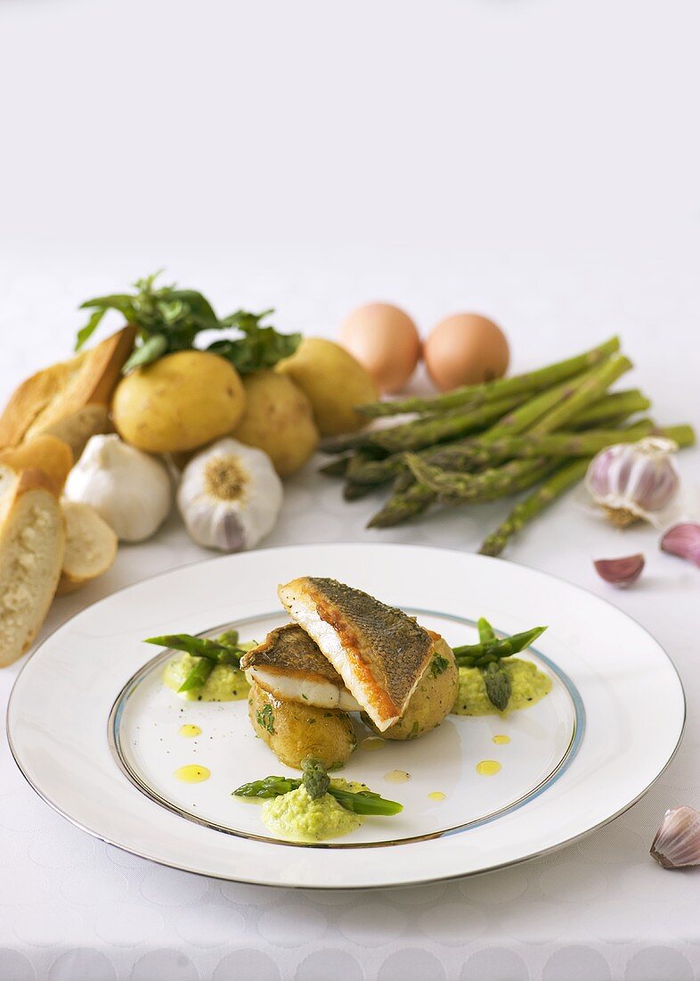 Fried sea bass on potatoes with green asparagus puree