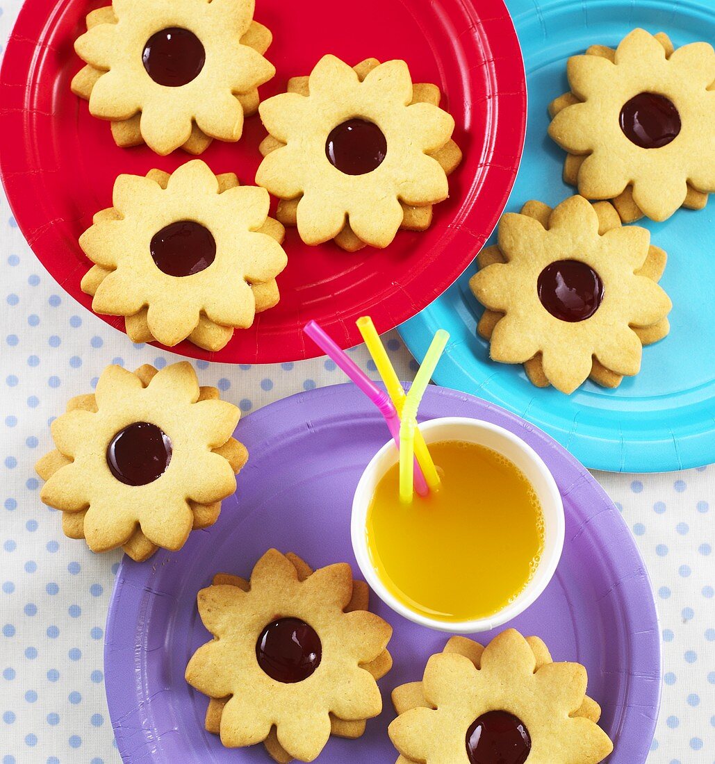 Flower-shaped jam biscuits and orange juice