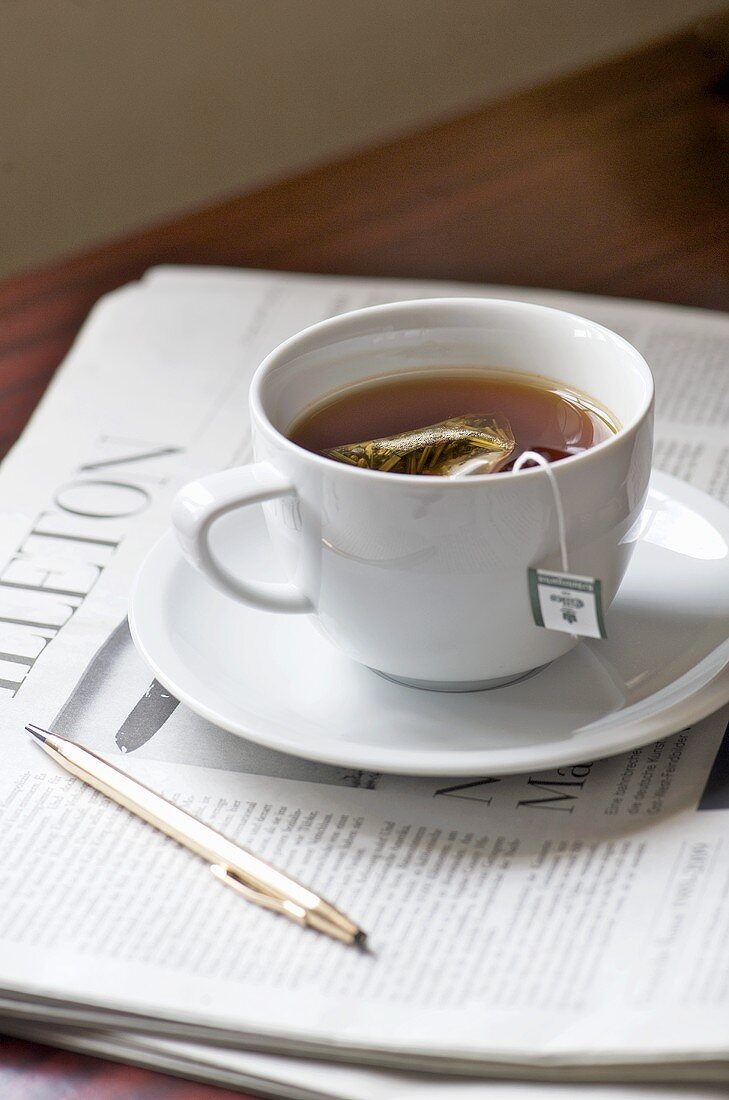 Tasse Kräutertee auf einer Zeitung