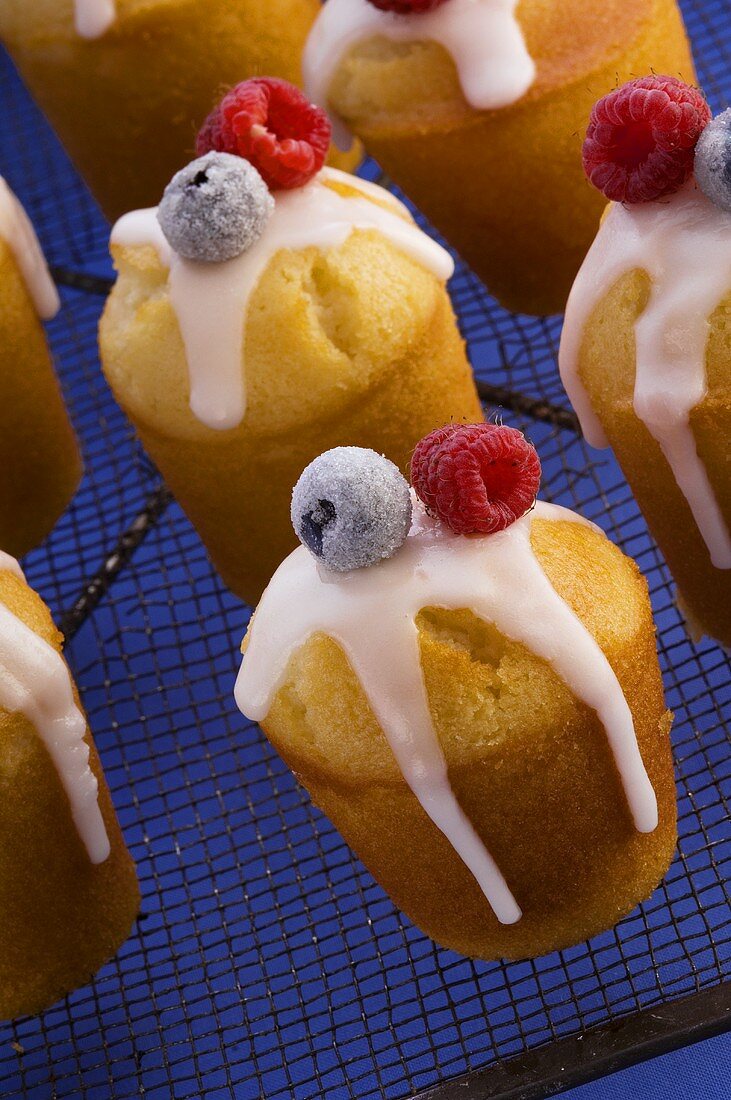 Iced buns with berries on cake rack