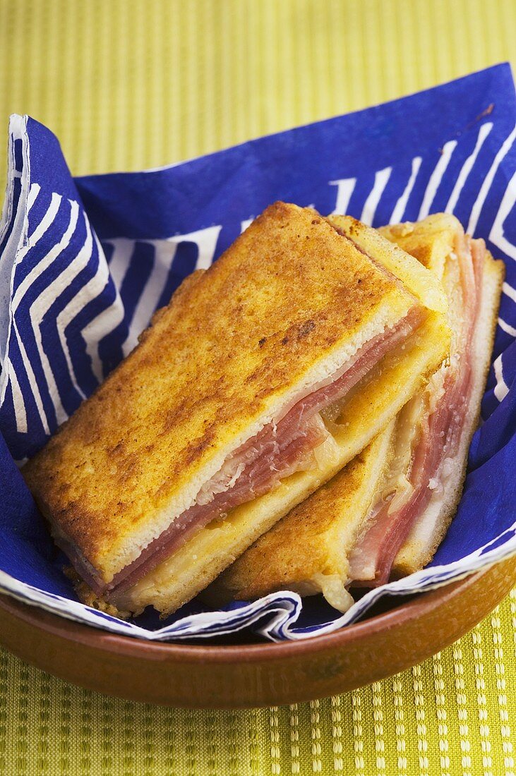 Fried ham and cheese sandwiches in bread basket
