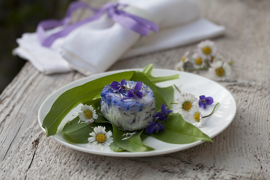 Goat's cheese with violets and daisies on ramsons (wild garlic)