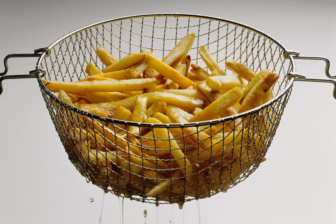 French Fries in Basket Lifted from the Fryer