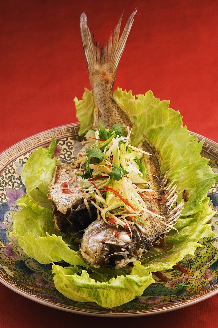 Fish with julienne vegetables on lettuce leaf (China)