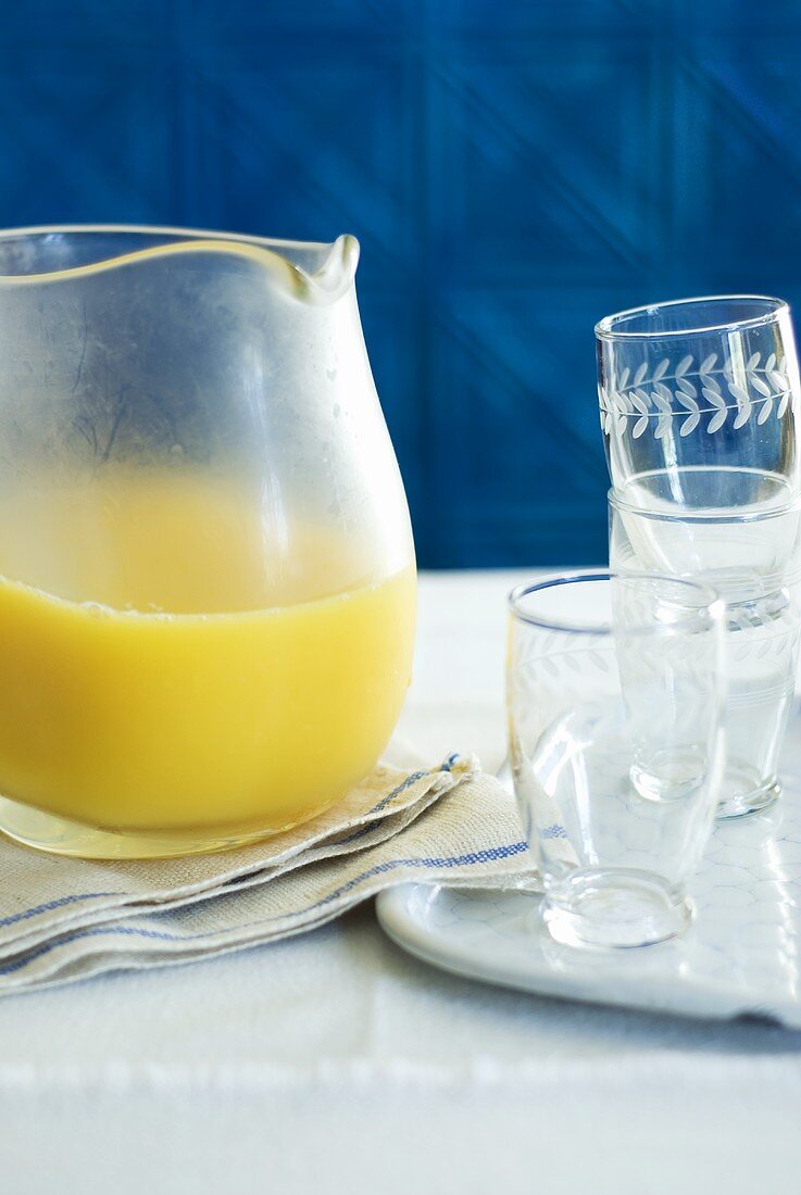 Ice-cold fruit juice in a jug, glasses