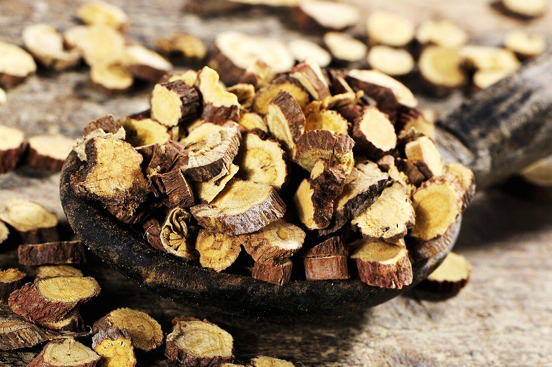 Dried Ural liquorice root on wooden spoon