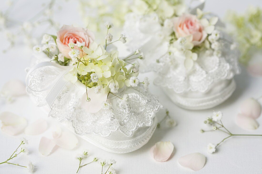 weiße Babyschuhe mit Rose und Schleierkraut