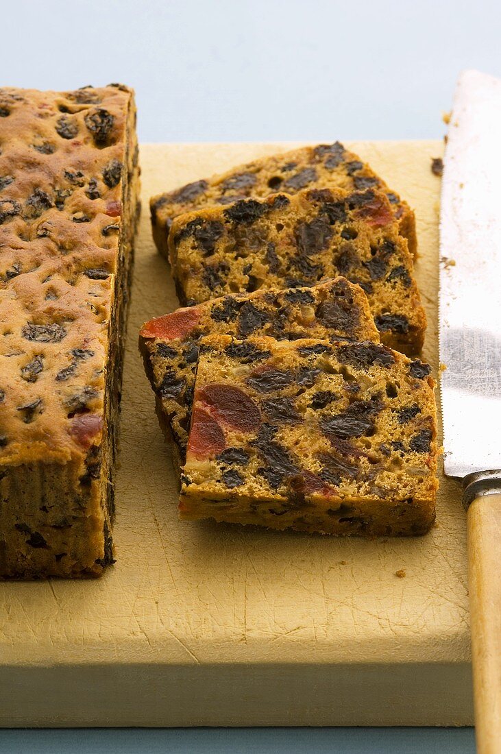 Fruit cake, partly sliced, on chopping board