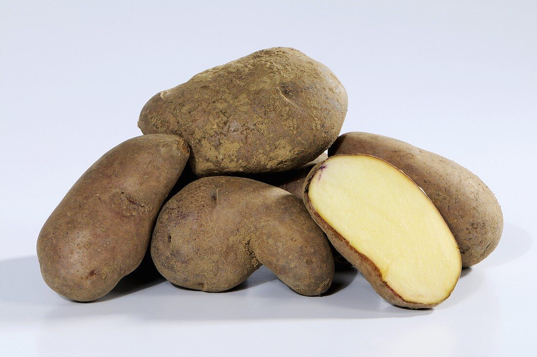 Several potatoes (variety 'Kepplestone Kidney'), whole and halved