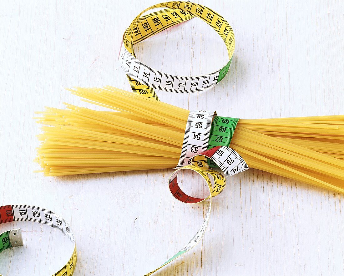 Symbolbild: Nudeldiät (Spaghetti mit Massband)