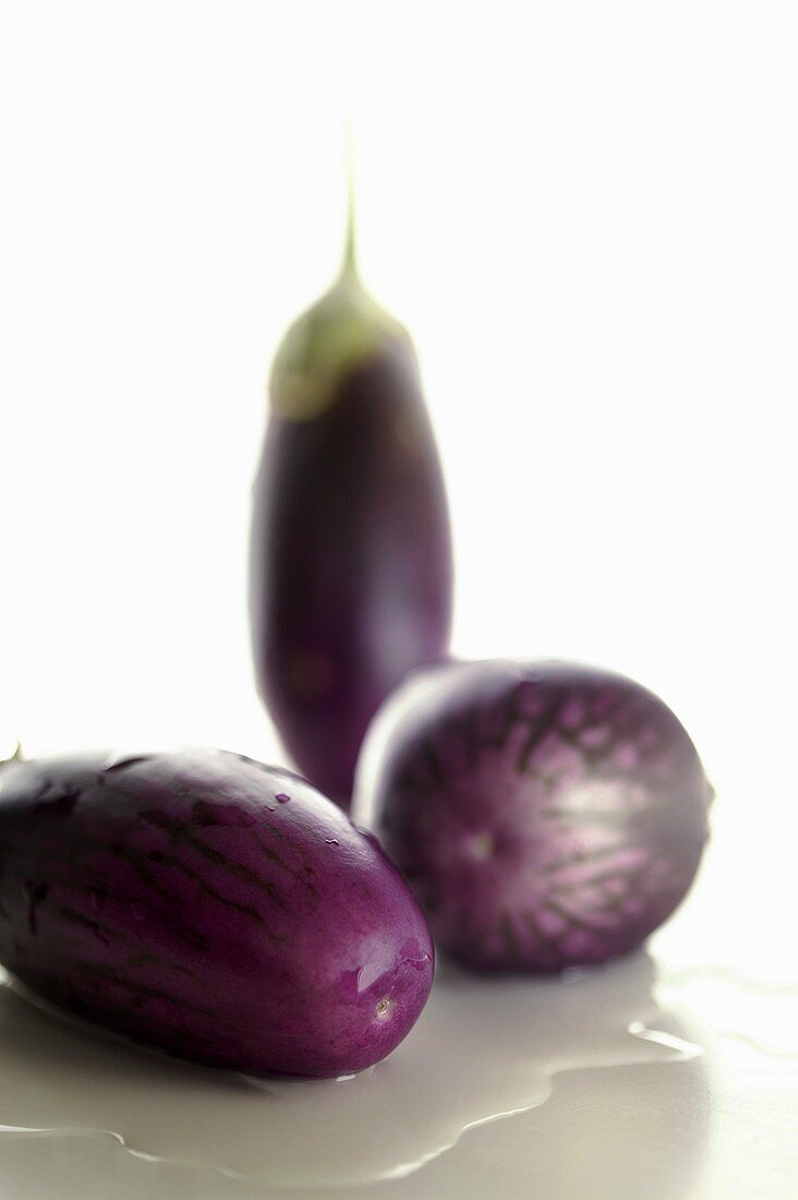 Three aubergines in a pool of water