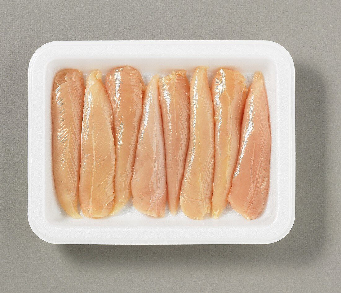 Several chicken breast fillets on plastic tray