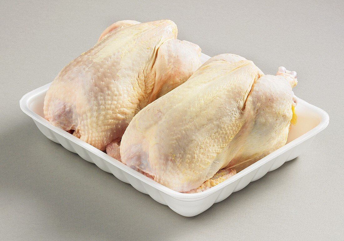 Two whole chickens on plastic tray