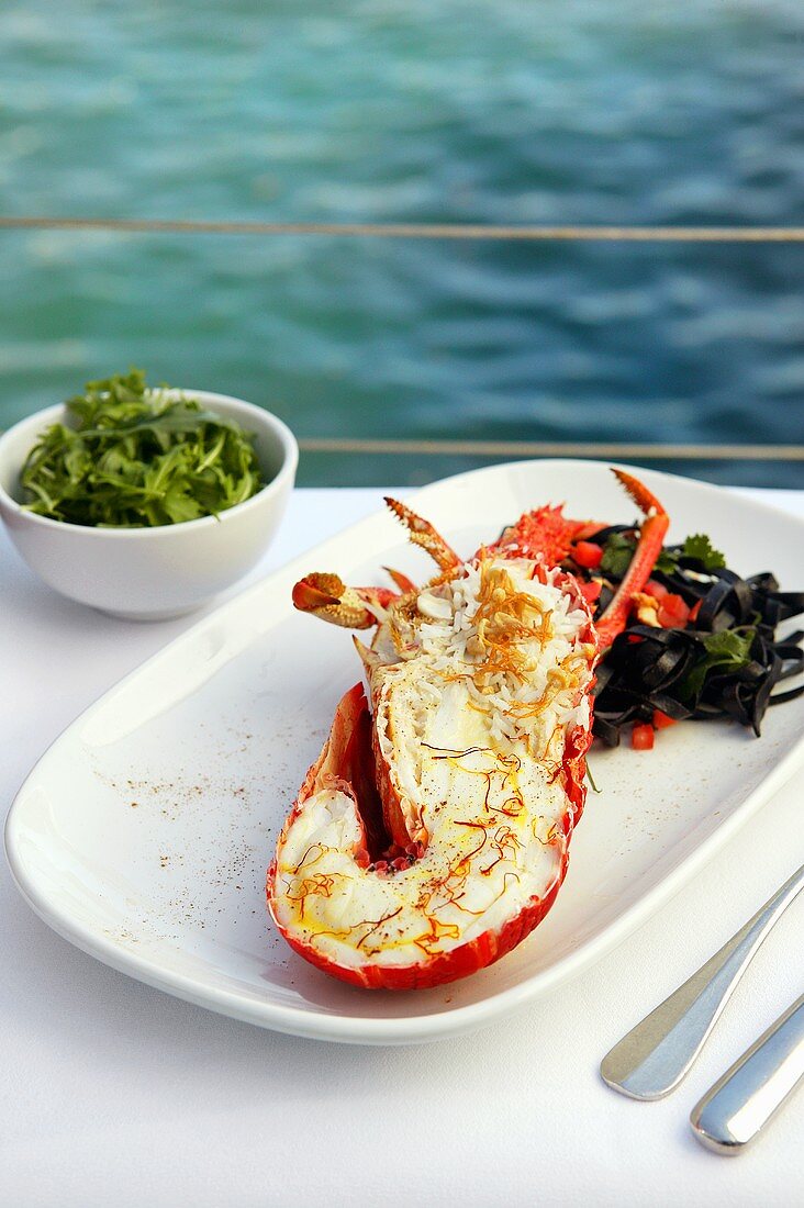Grilled lobster with saffron on table by sea