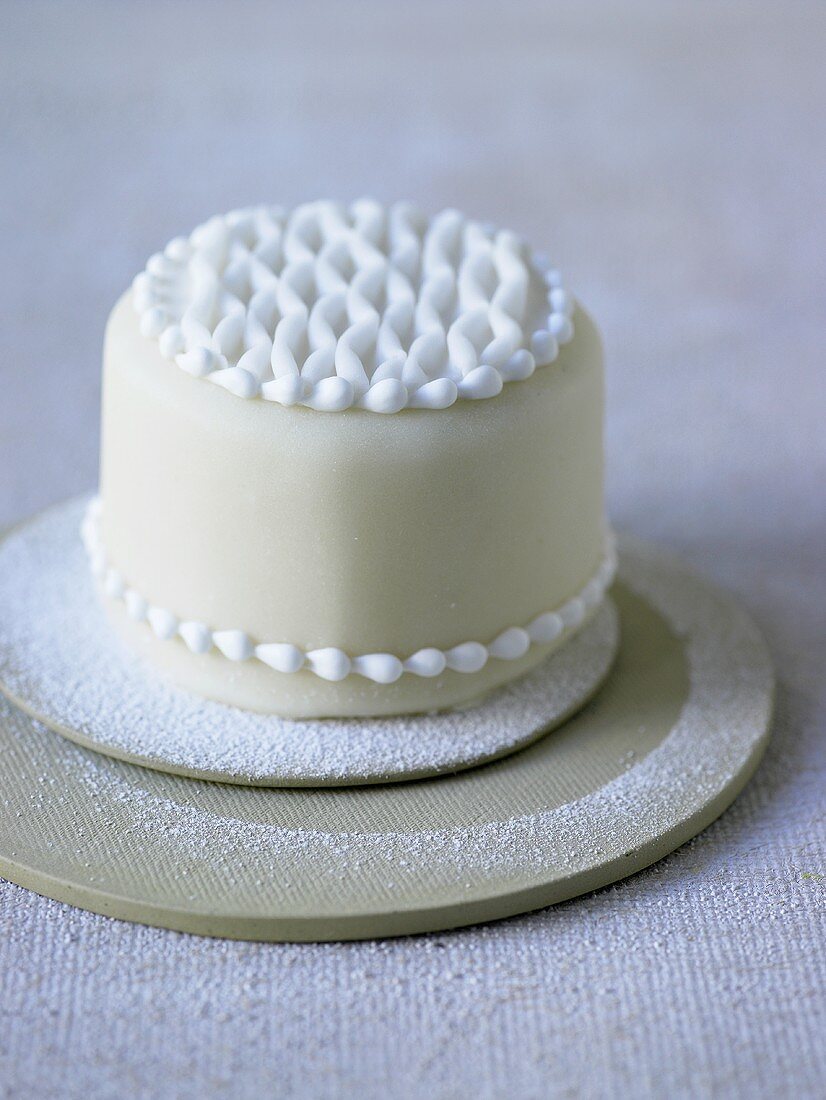 Small white cake decorated with icing