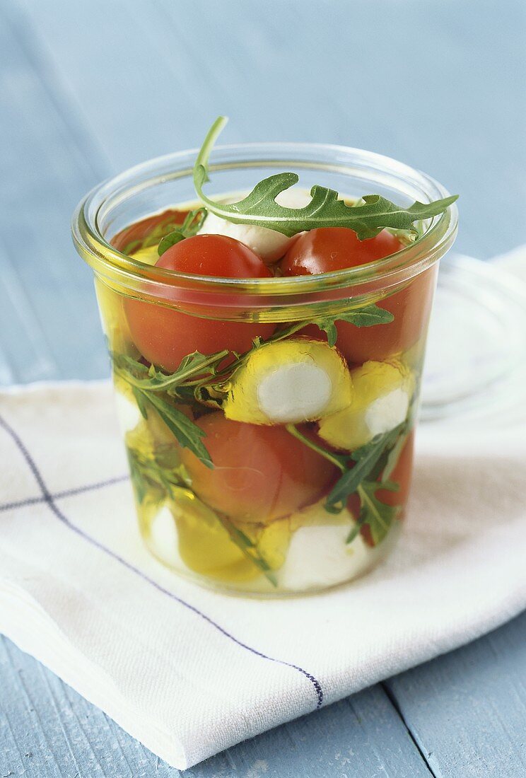 Marinated cherry tomatoes with mozzarella and rocket in jar