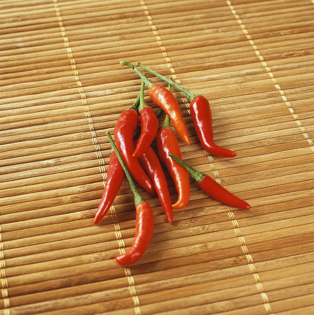 Fresh red chili peppers on bamboo mat