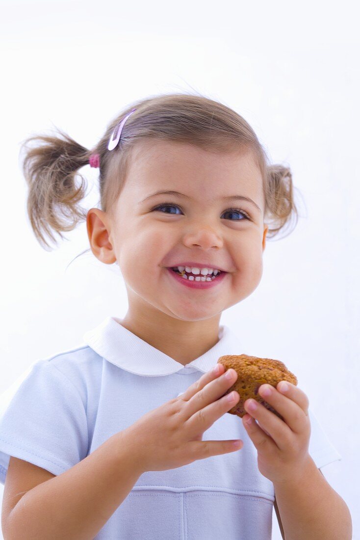 Kleines Mädchen hält Muffin