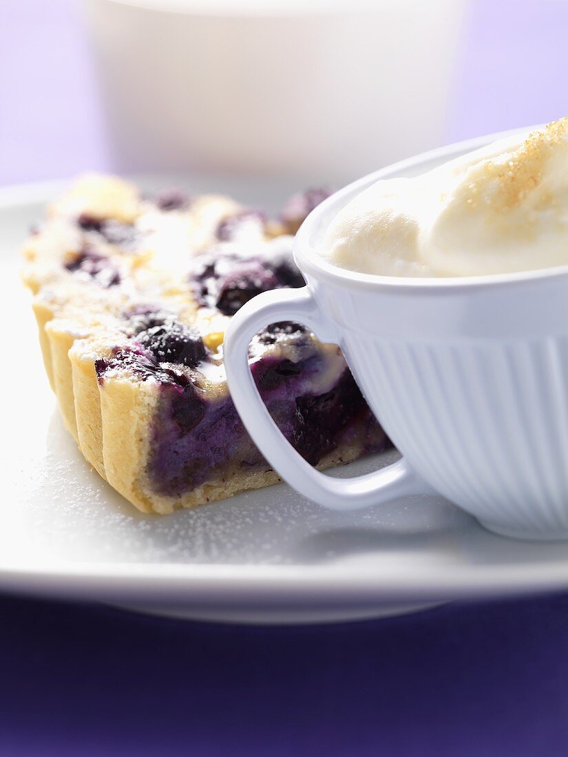 Piece of blueberry tart with cream
