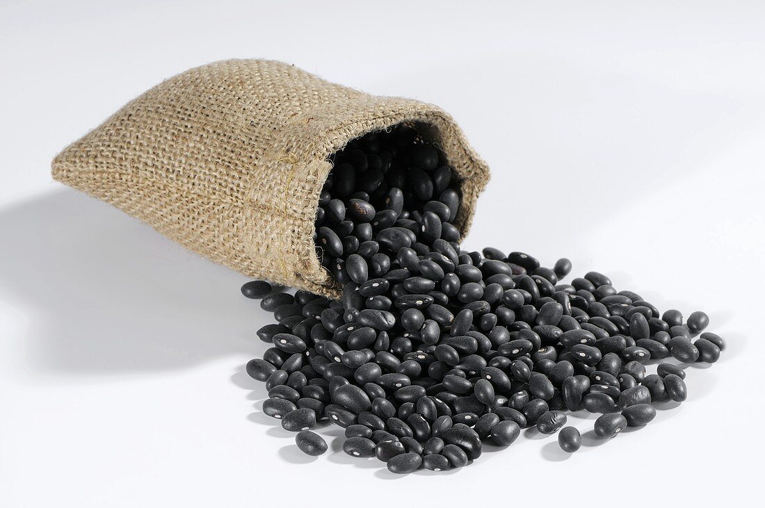 Black beans spilling out of hessian sack