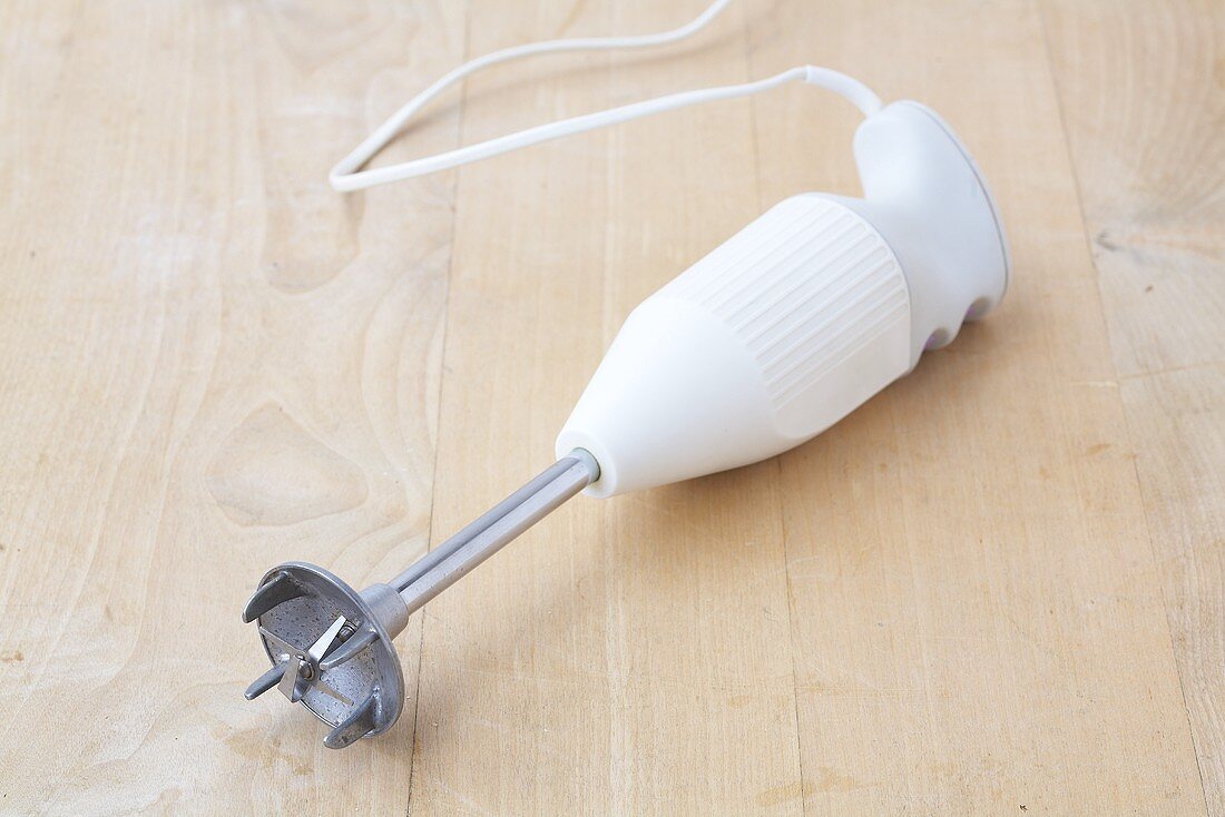 A hand blender on a wooden background
