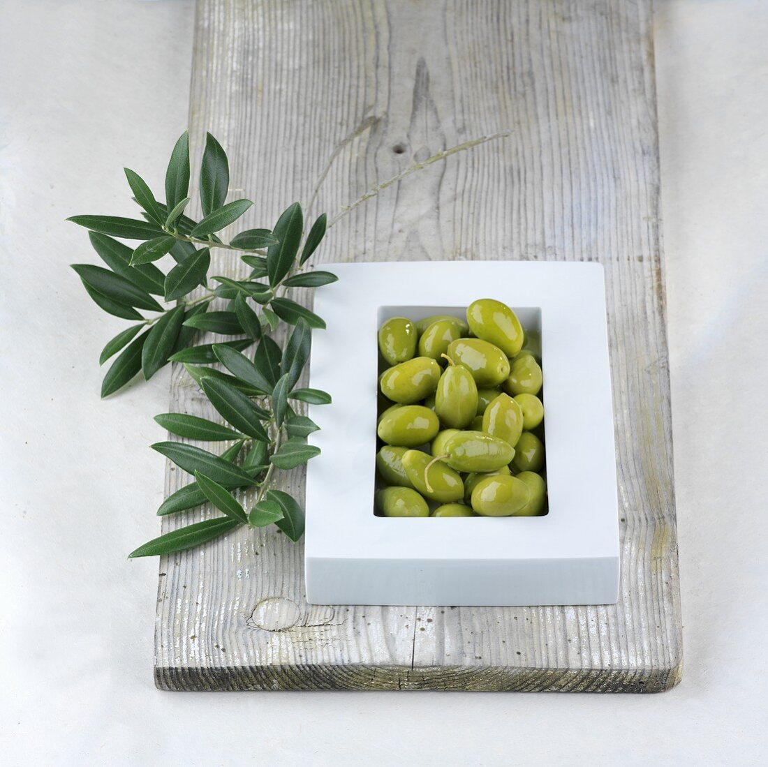Grüne Oliven und Olivenzweig