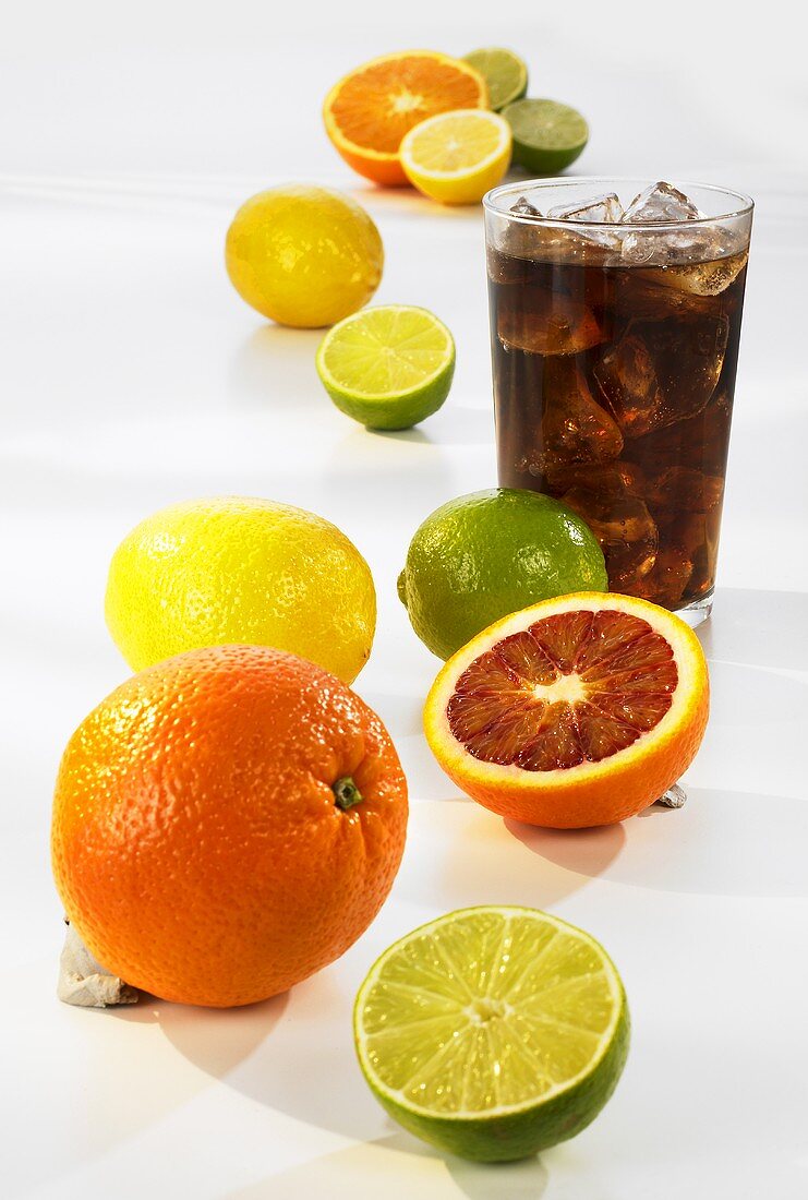 A glass of cola with ice cubes, citrus fruit