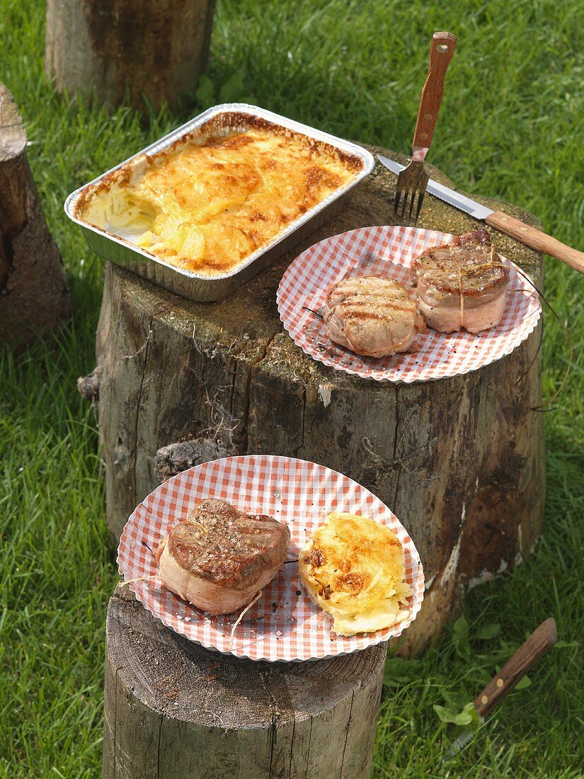 Bacon-wrapped entrecote steak and loin of pork with potato gratin