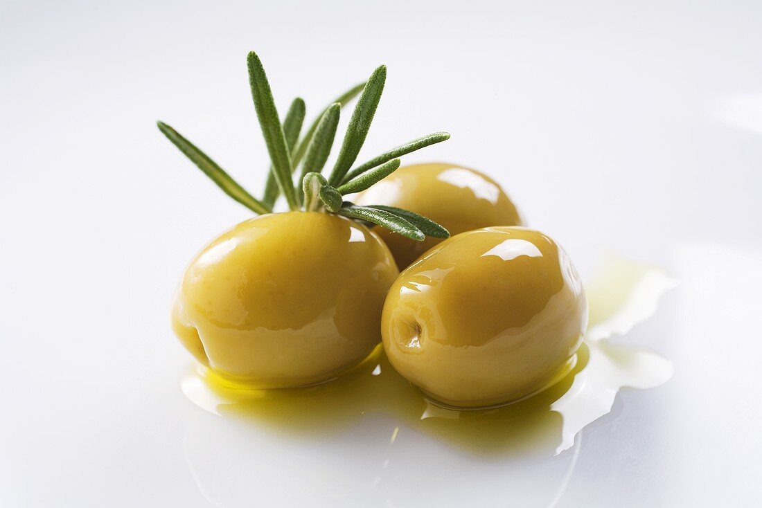 Grüne Oliven mit Olivenöl und Rosmarin