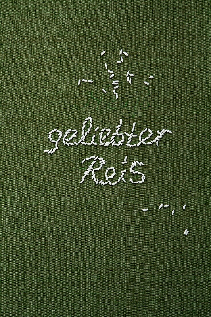 The words 'geliebter Reis' ('beloved rice') written in grains of rice