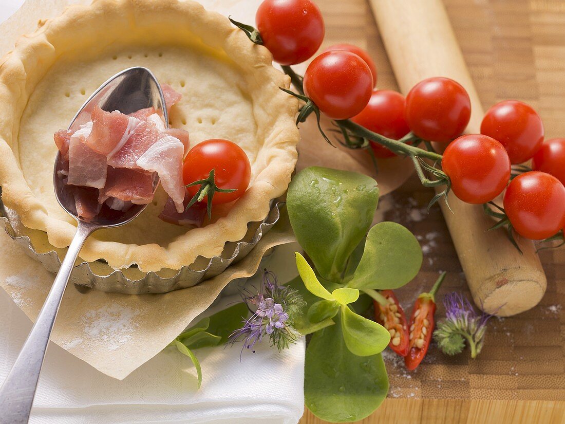 Ingredients for tarts: pastry cases, bacon, tomatoes, herbs