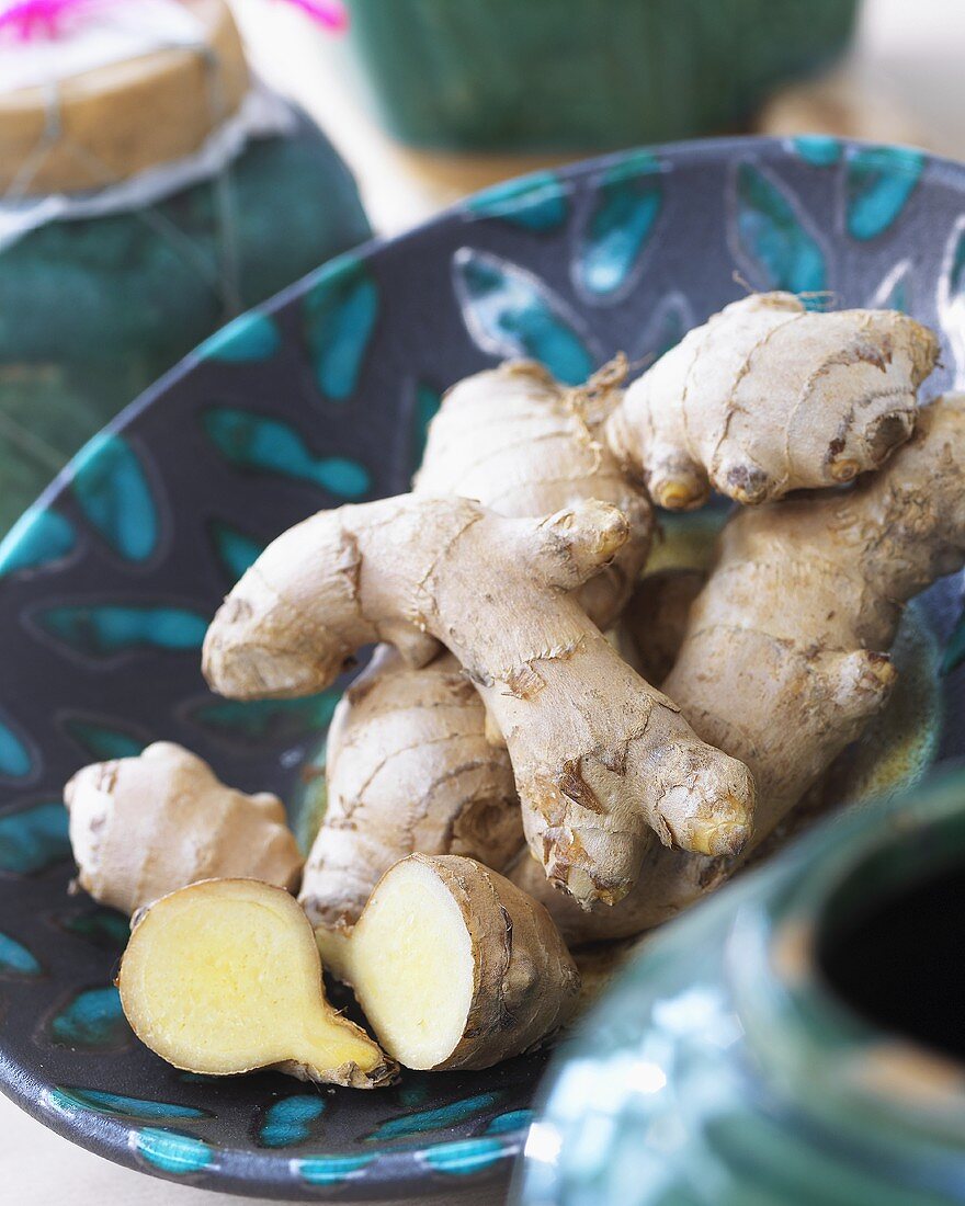 Fresh ginger roots in ceramic bowl