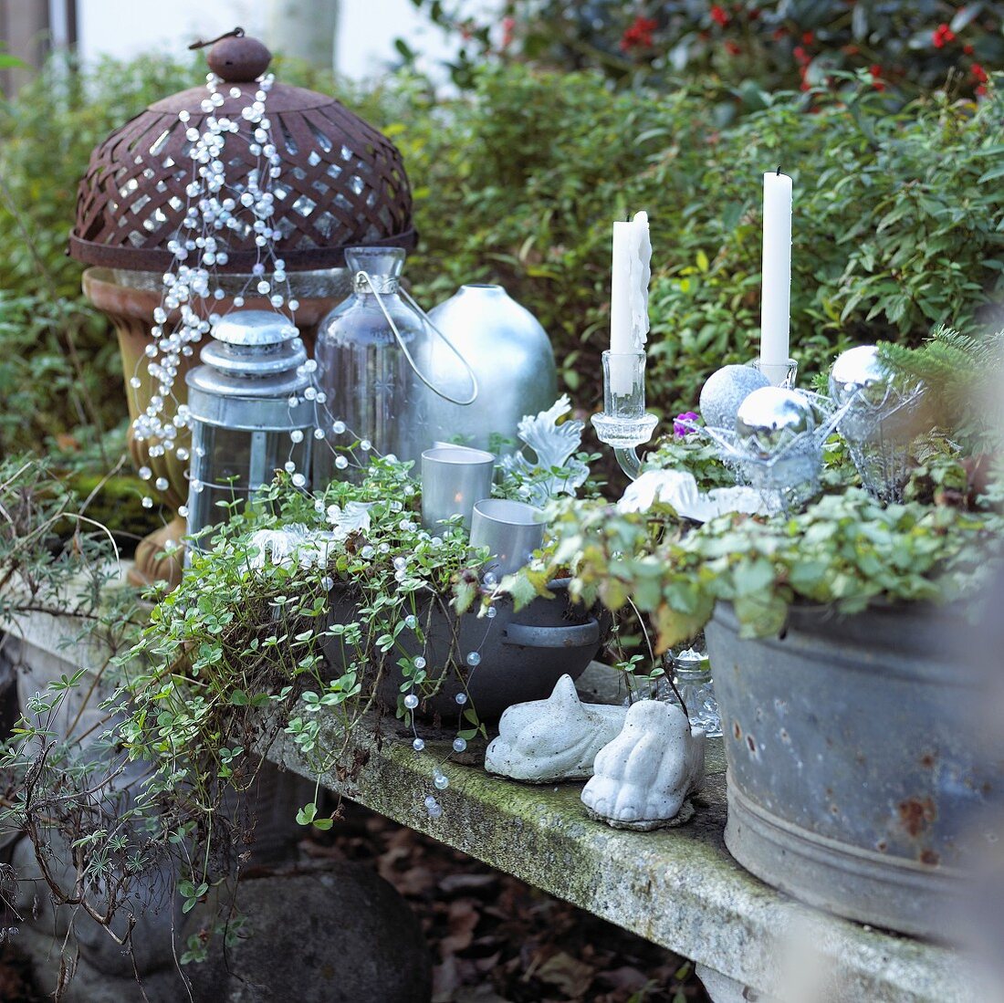 Christmas decorations in garden: candles, lanterns and strings of beads