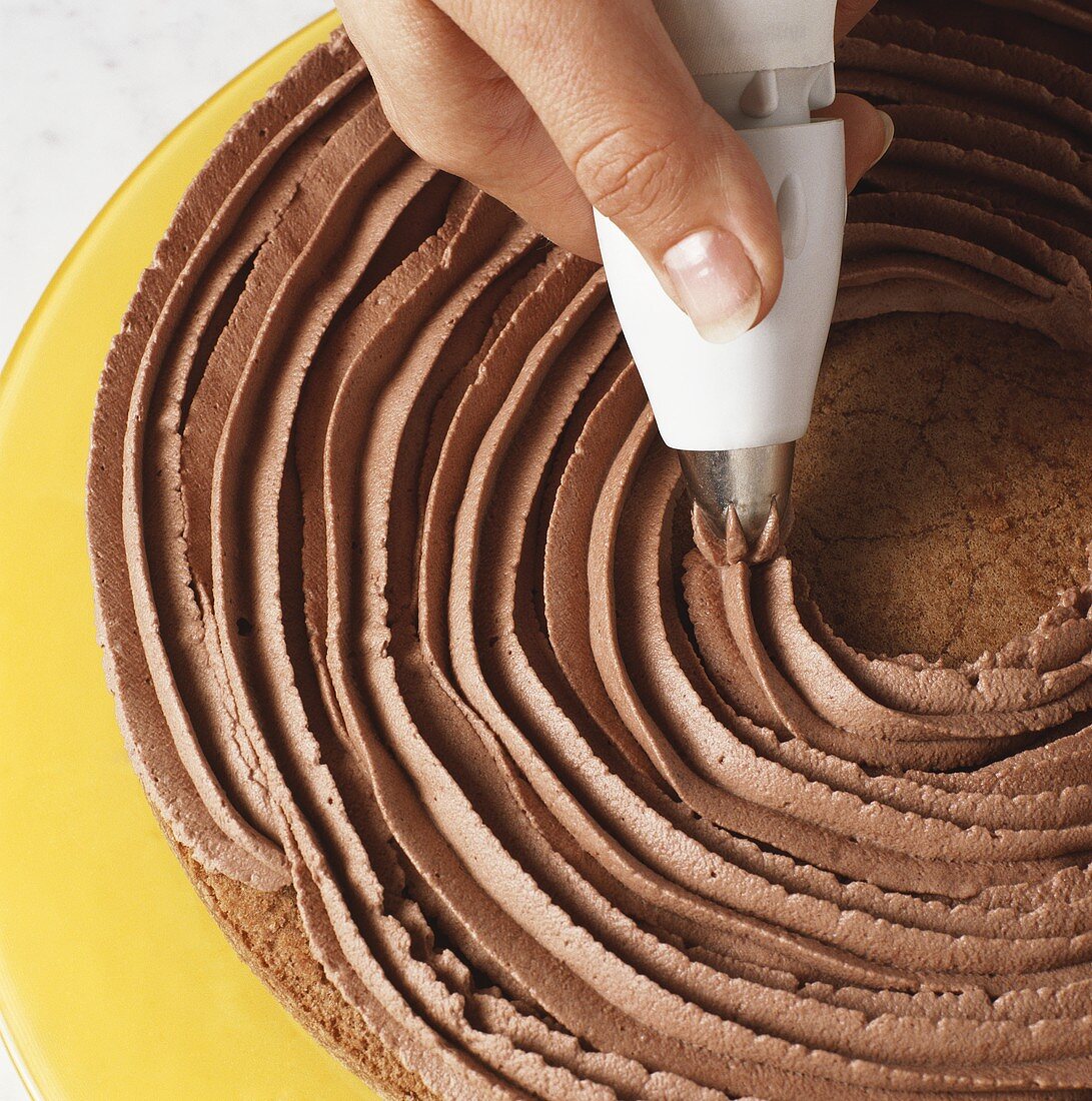 Torte mit Schokoladencreme aus Spritzbeutel verzieren