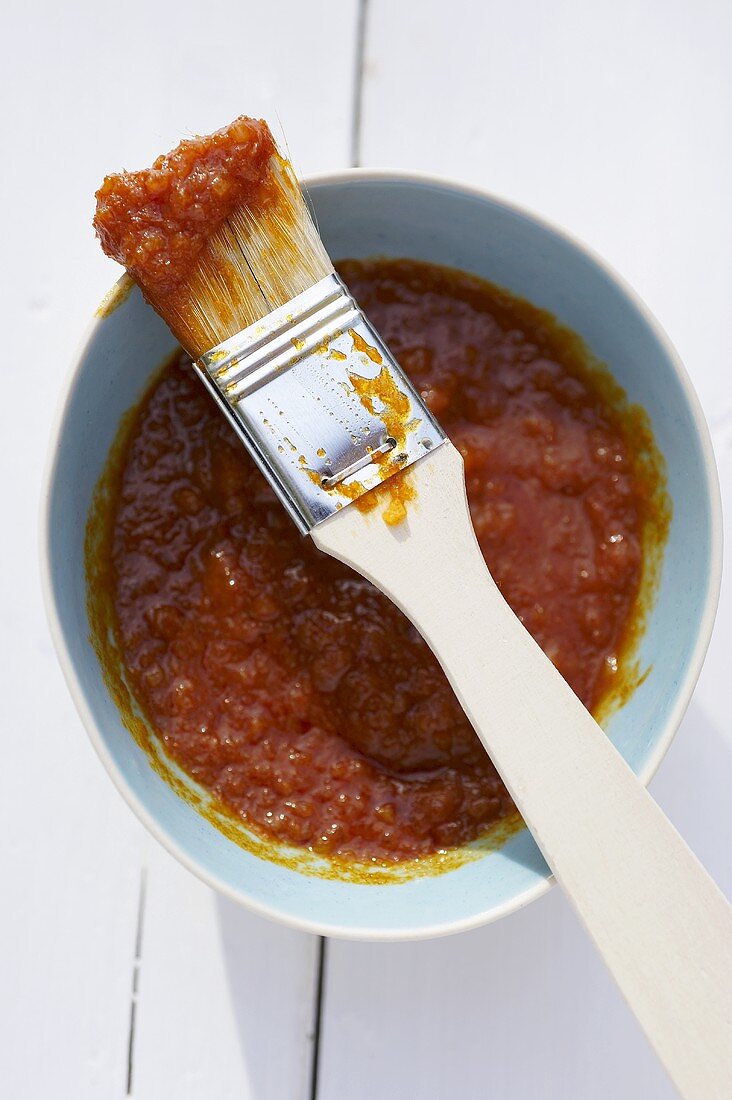 Curry-Zwiebel-Paste in Schälchen mit Pinsel