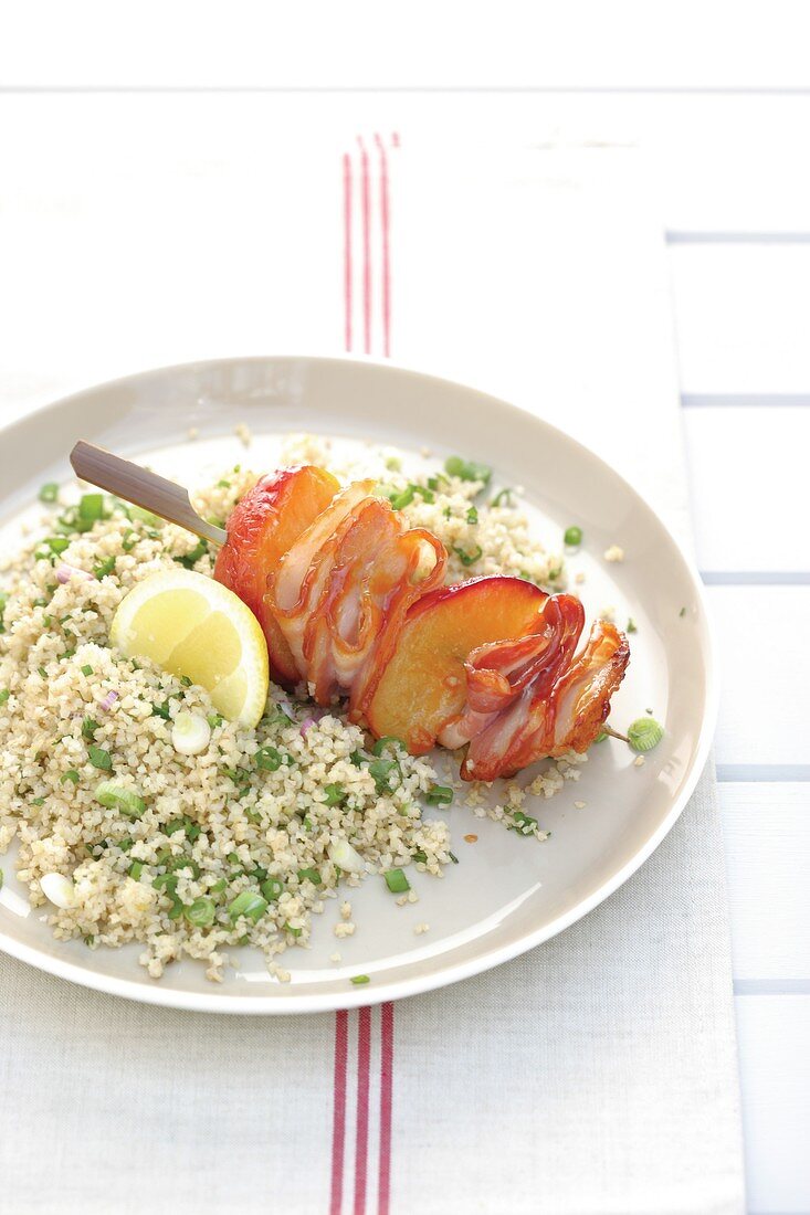 Plum and bacon skewer with bulgur salad