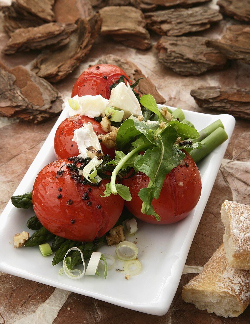 Baked tomatoes with green asparagus, goat's cheese and walnuts