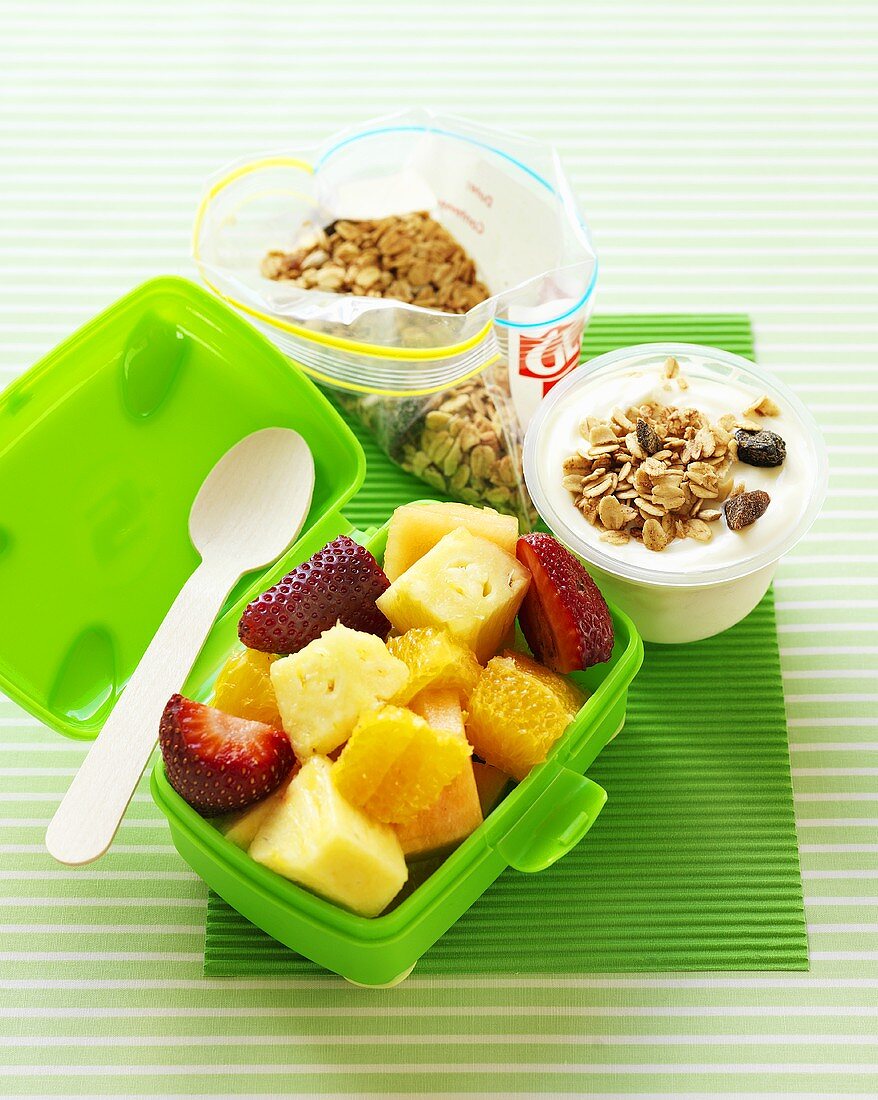 Fruit salad in lunch box, yoghurt with muesli