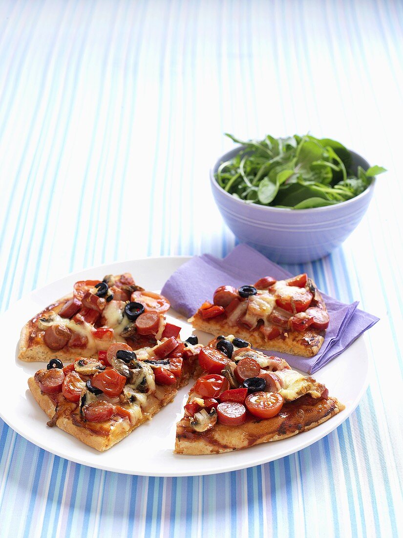 Slices of pizza topped with tomatoes and olives