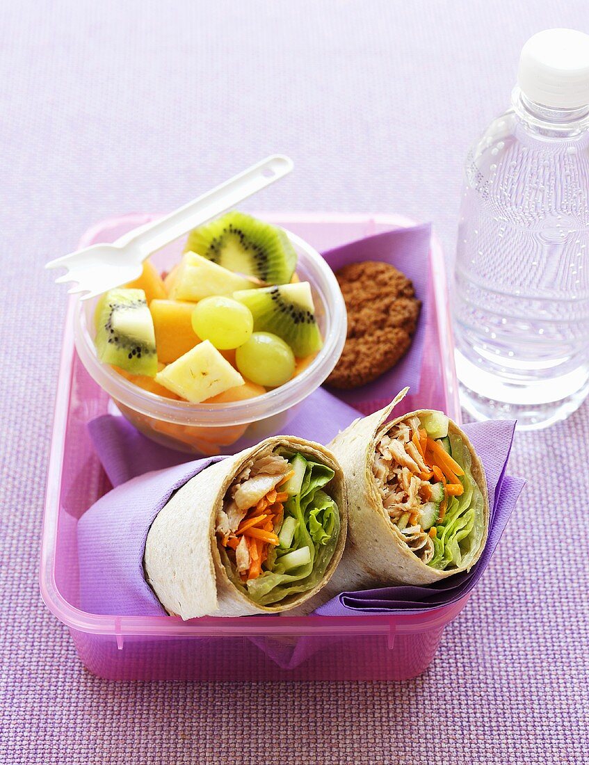 Lunchbox mit Thunfisch-Wraps und Obstsalat